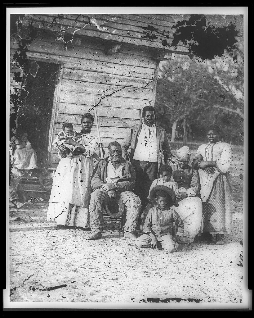 "Five generations on Smith's Plantation," photograph showing a group of Black people outside a slave cabin
