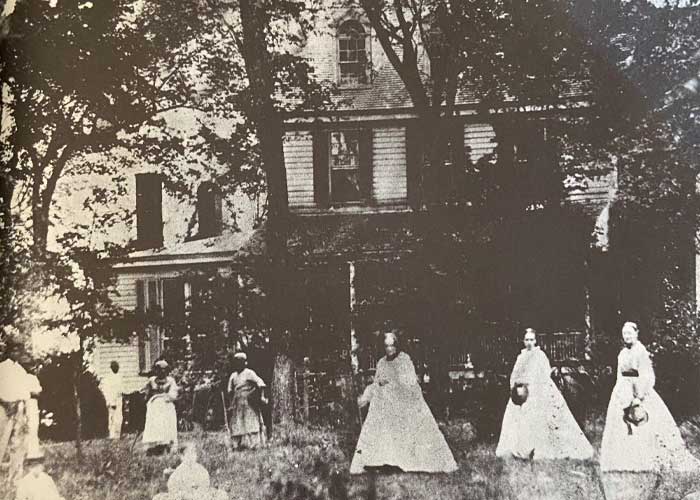 Photograph of Plantation House, with women standing in yard